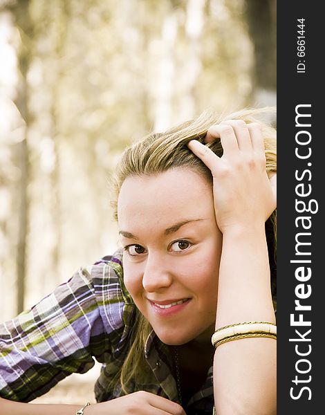 Young laying woman smiling at camera.