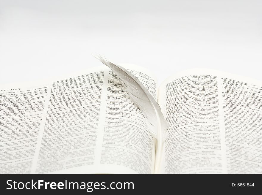 Book with feather on white background