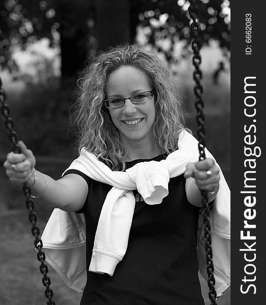 Curly girl with glasses on swing. Curly girl with glasses on swing