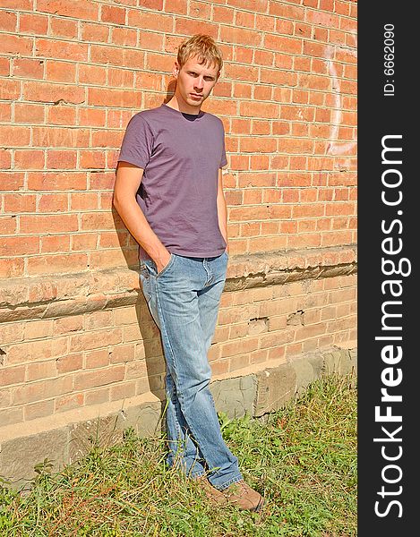 Young stylish man stand near brick wall.