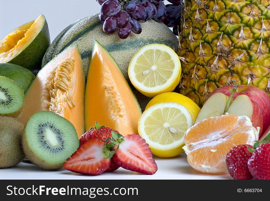 A heap of cut tropical fruits on a white background, very colorful image