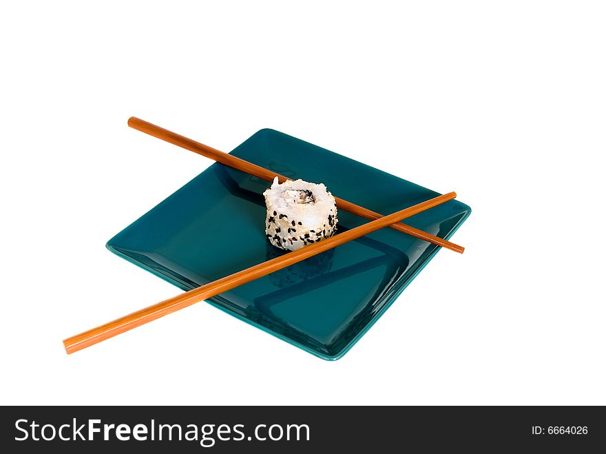 Plate with traditional Japanese sushi, sashimi rolls, shop sticks on the side of the plate. Studio shot.