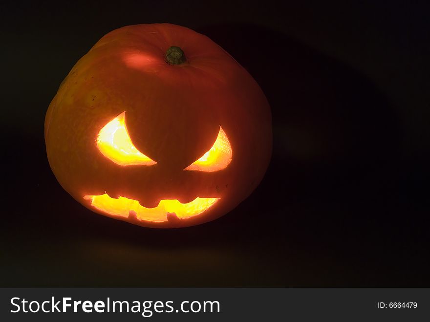 Evil Pumpkin head with light inside in complete darkness