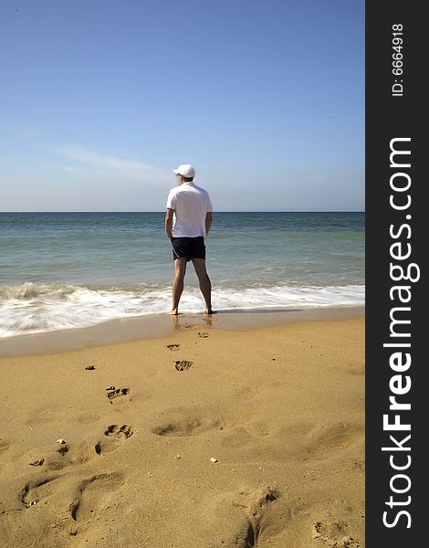 Man in white shirt watchig the ocean. Man in white shirt watchig the ocean