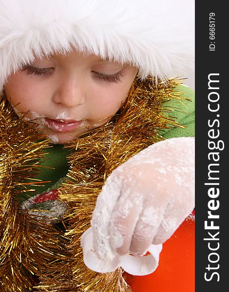 Toddler wearing a christmas hat, baking christmas cookies