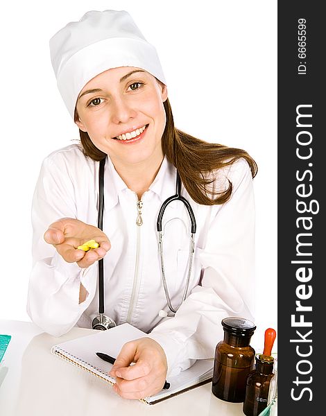 The affable young woman-doctor looks in a shot and holds in a palm some yellow tablets. The affable young woman-doctor looks in a shot and holds in a palm some yellow tablets