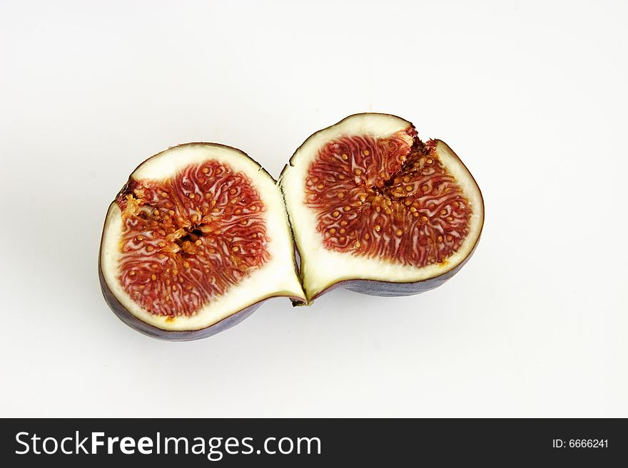 One single fig cut in half showing the seeds inside. One single fig cut in half showing the seeds inside