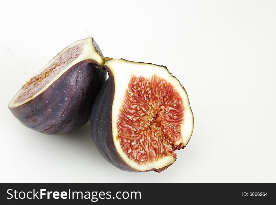 One single fig cut in half showing the seeds inside. One single fig cut in half showing the seeds inside