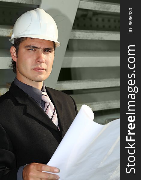 Business background: builder standing at building site.