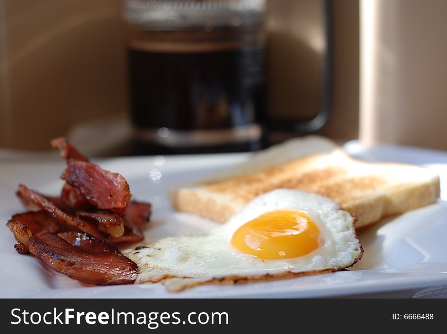 Bacon, Eggs and Toast on a plate with coffee in a plunger. Shallow depth of field. Bacon, Eggs and Toast on a plate with coffee in a plunger. Shallow depth of field.