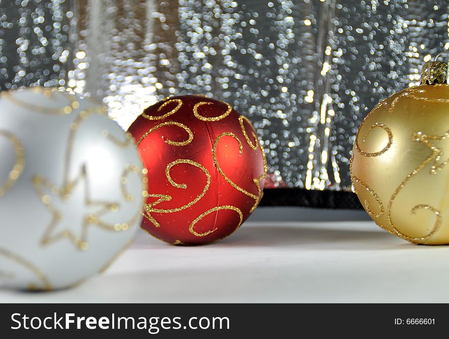 Red, gold and silver Christmas ornaments on a silver background