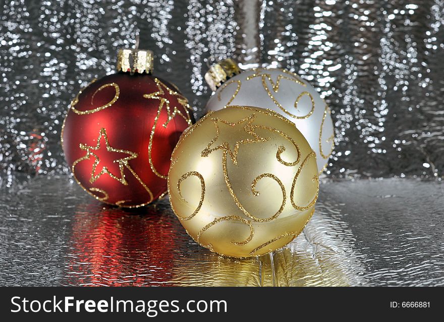 Red, gold and silver Christmas ornaments on a silver background