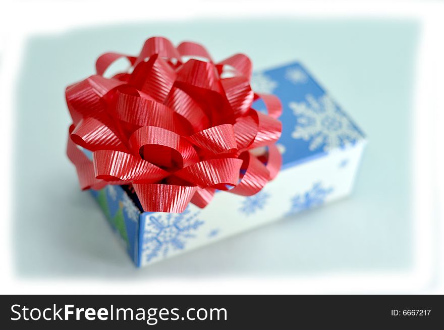 Christmas gift box with red ribbon on top