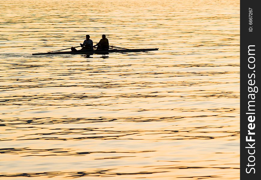 A pair of rowers captured on the water at daybreak. A pair of rowers captured on the water at daybreak.