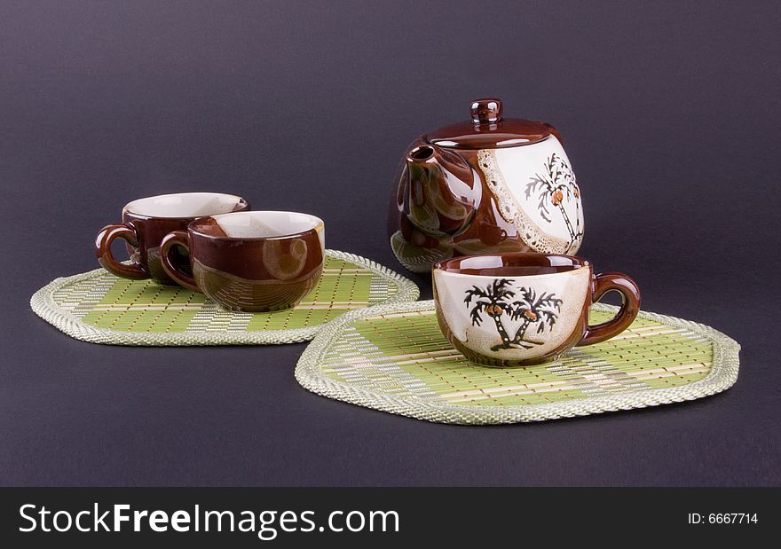 Composition of teapot and cups isolated on violet background