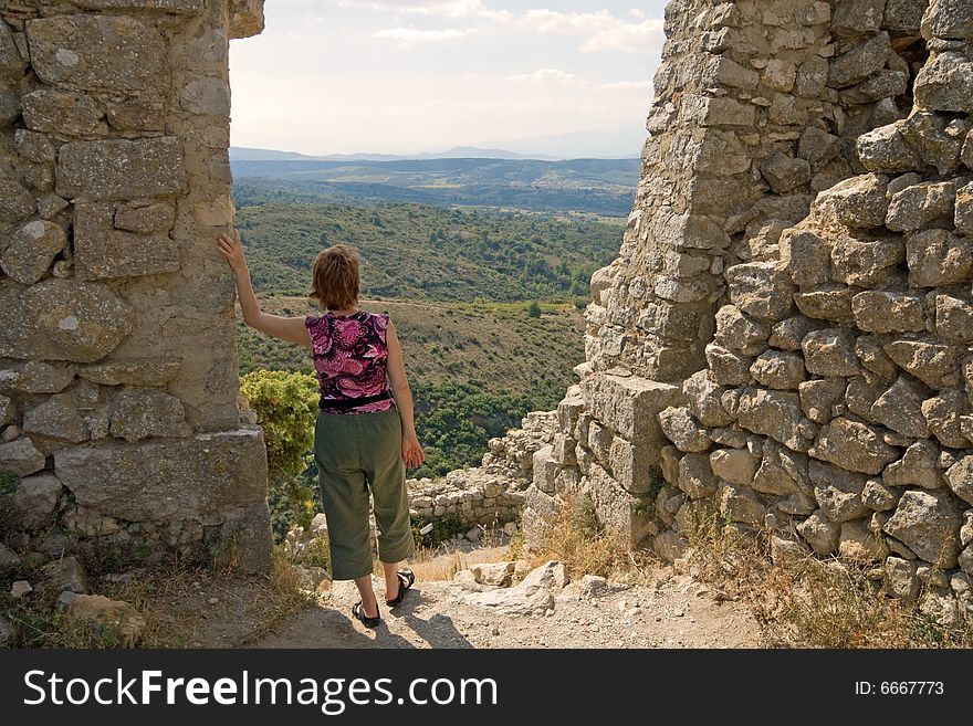 woman with flowered blouse is taking a view  from Chateau Aguilar, south france. woman with flowered blouse is taking a view  from Chateau Aguilar, south france.