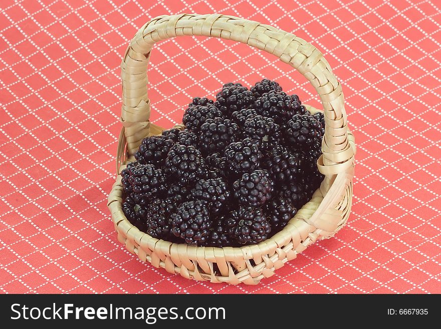 Fresh blackberries in a basket on red background. Fresh blackberries in a basket on red background