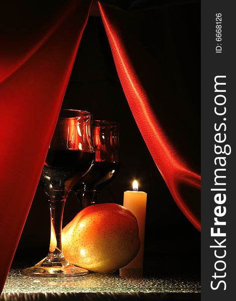 Still-life with red wine, pear and luminous candle. Still-life with red wine, pear and luminous candle