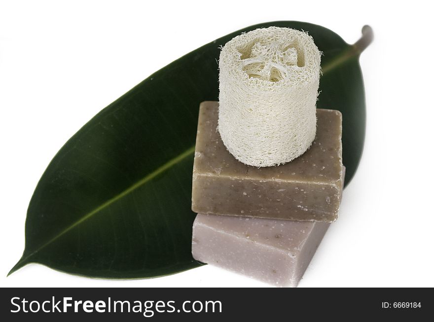 Beautiful spa still life setting with hand made soap and tropical green leaf