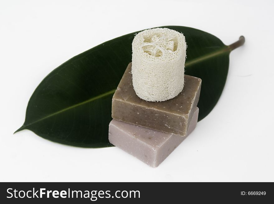 Beautiful spa still life setting with hand made soap and tropical green leaf