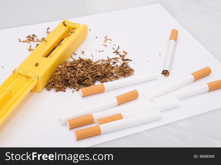 Cigarette maker, tubes and tobacco on white background