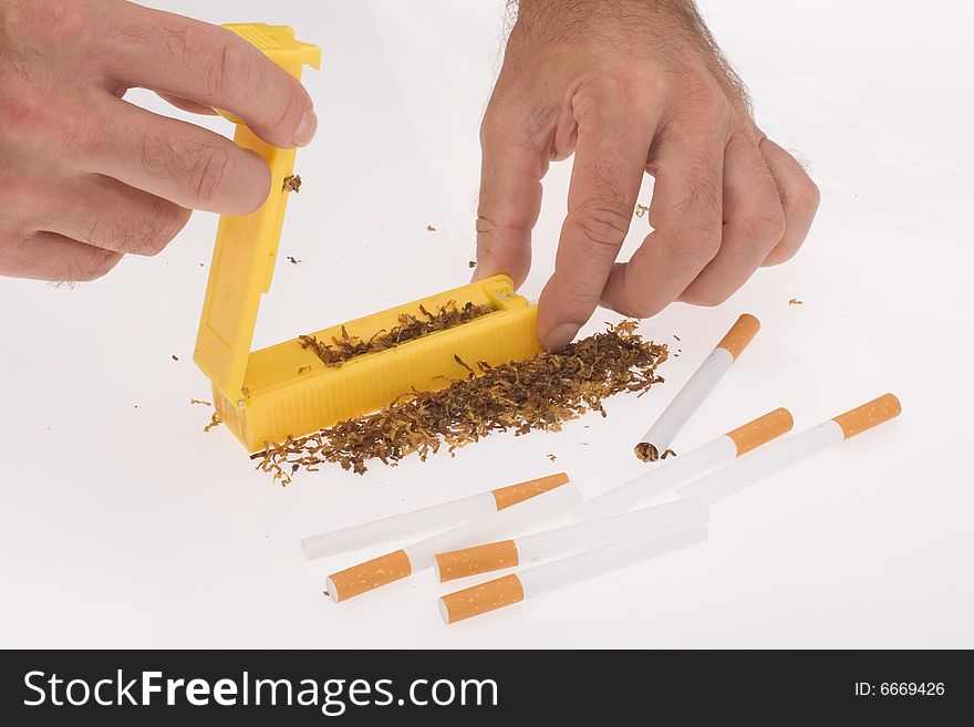 Hands of man making cigarettes on white background