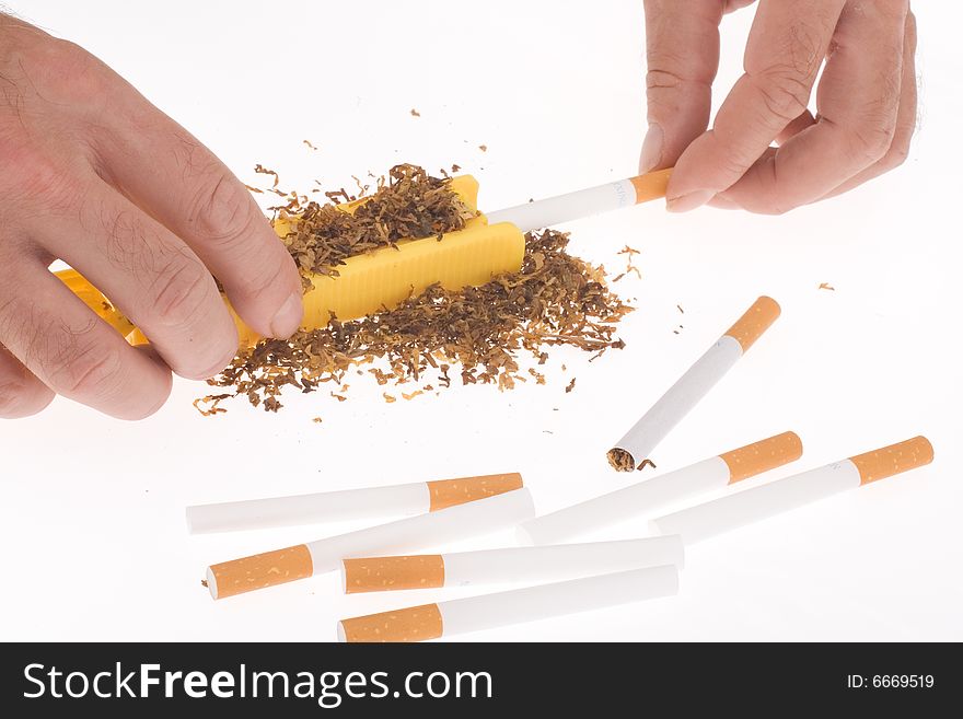 Hands of man making cigarettes on white background