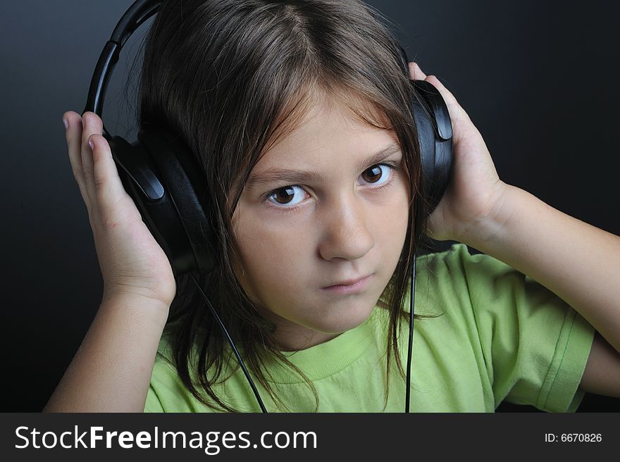 Portrait of a little girl with ear phones listening music. Portrait of a little girl with ear phones listening music