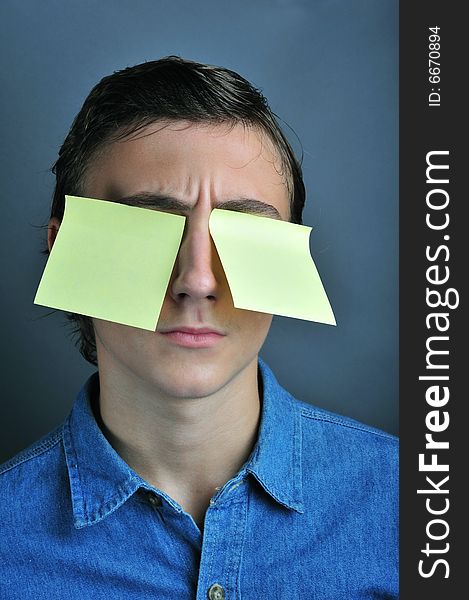 Portrait of a boy holding yellow notes on eye. Portrait of a boy holding yellow notes on eye