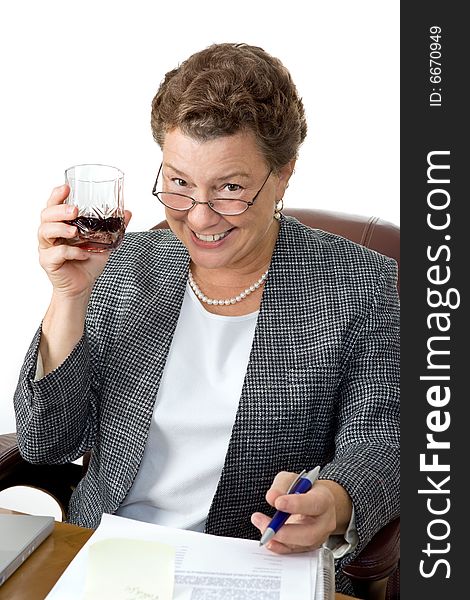 A mature businesswoman drinking on the job, office setting.