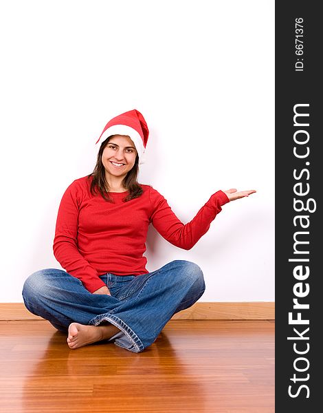 Young woman with red christmas hat sitting in house floor