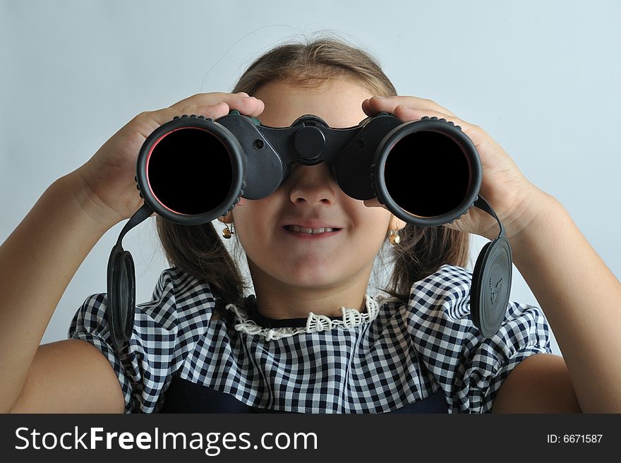 Portrait of a little girl looking through binoculars. Portrait of a little girl looking through binoculars