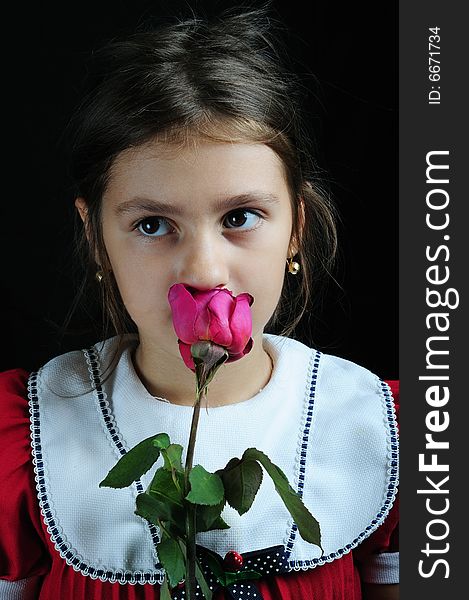 Close up portrait of a little girl smelling a roze. Close up portrait of a little girl smelling a roze