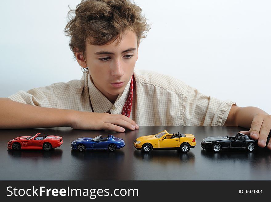 A teen playing with cars on a table. A teen playing with cars on a table