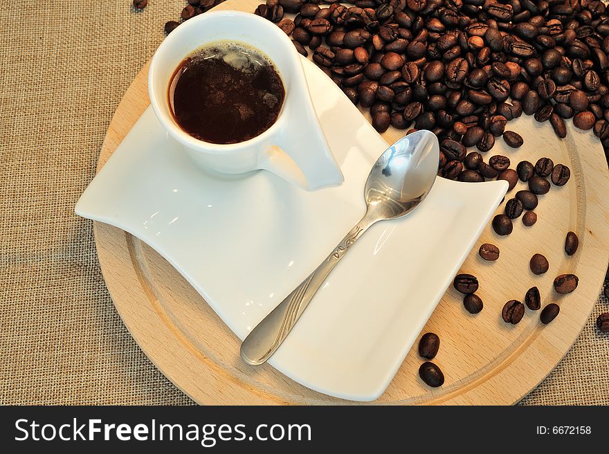 Close up of a cup of coffee and beans