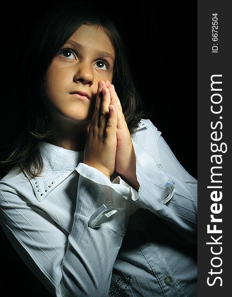 Close up portrait of a little girl praying