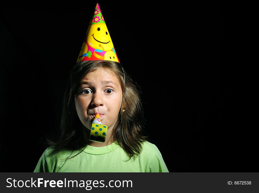 Portrait of a girl with party horn blowing in blowers