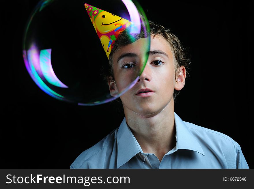 Young boy looking through soap bubbles, children's birthday party