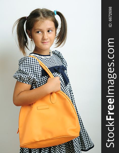 Little girl portrait holding an orange handbag on her shoulder. Little girl portrait holding an orange handbag on her shoulder