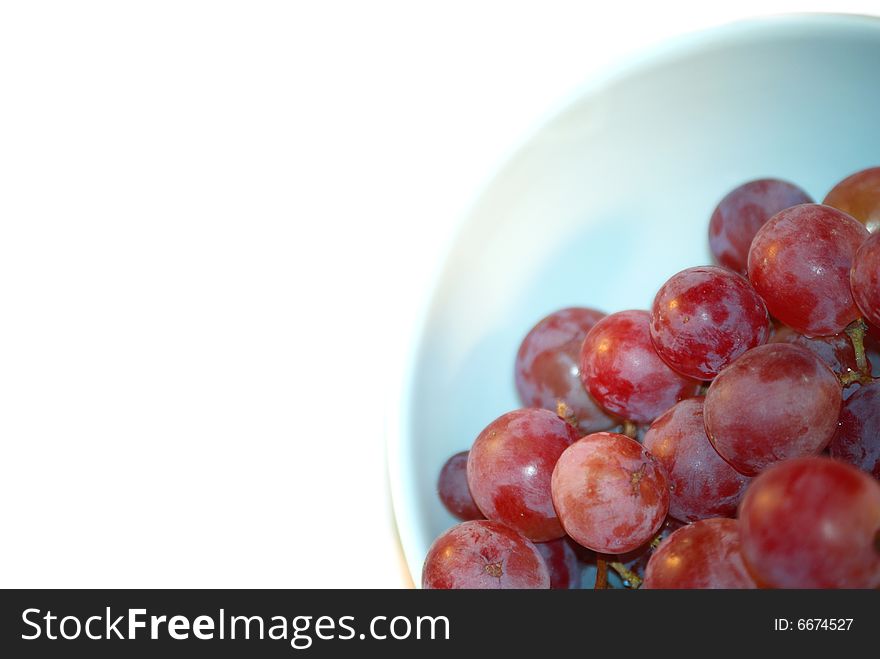 Red fresh grape in blue cup staying on the corner. Red fresh grape in blue cup staying on the corner.