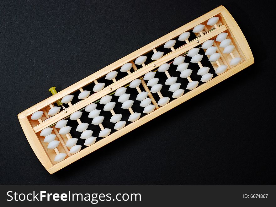An abacus, a traditional calculating device on black background. An abacus, a traditional calculating device on black background