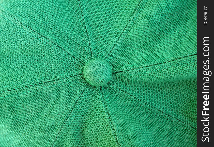 A close up photo of the top of a green hat with fabric texture