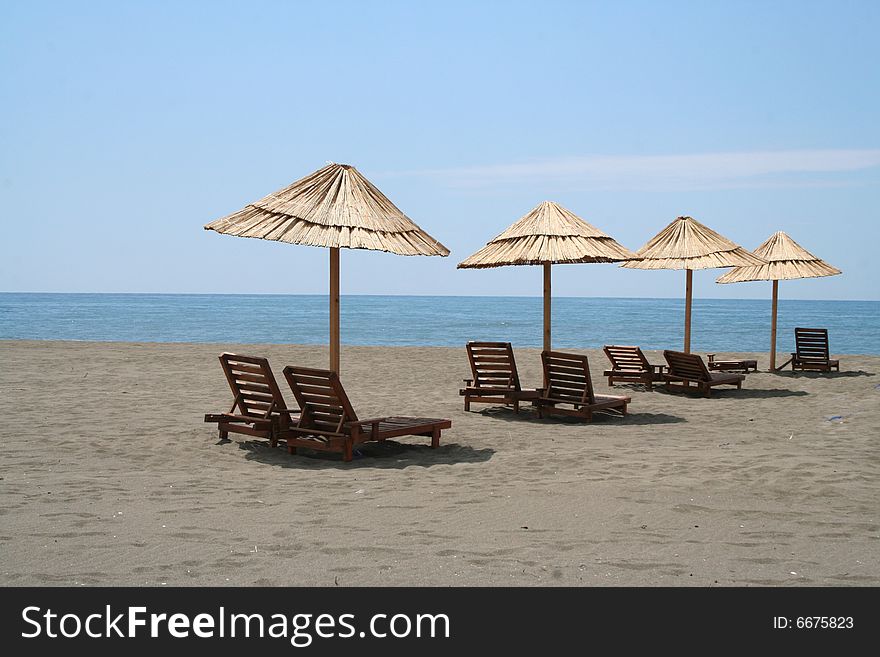 Beach umbrellas and wooden deck shairs