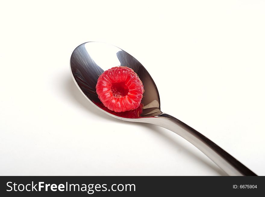 Close up of red raspberry on a spoon, white background. Close up of red raspberry on a spoon, white background