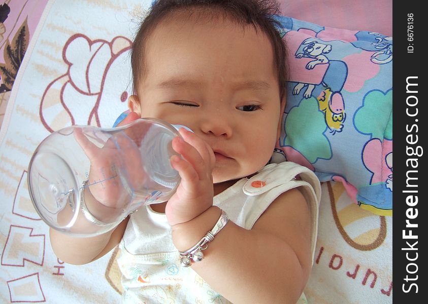 A baby is drinking water with baby's bottle. A baby is drinking water with baby's bottle