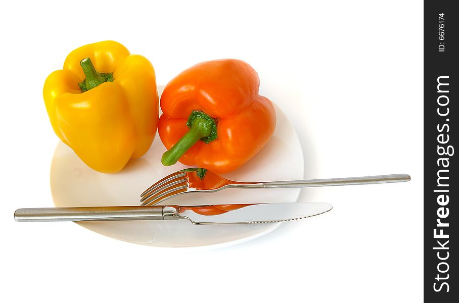 Pepper on a white plate, a knife and a fork. Pepper on a white plate, a knife and a fork