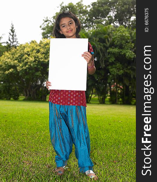 Asian girl holding a placard in a park