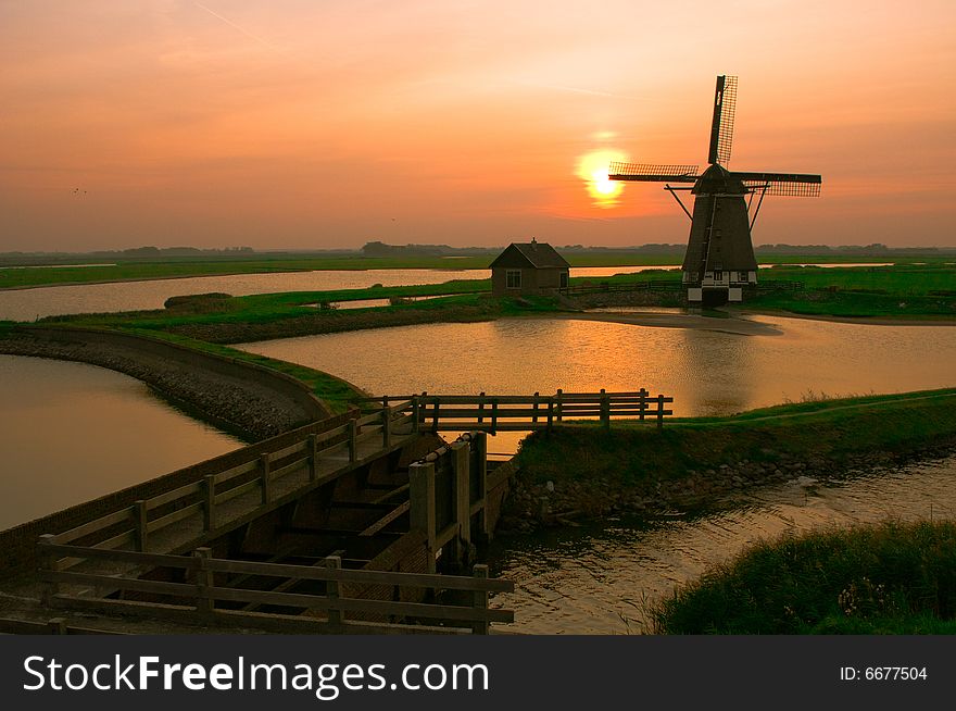 A classical landscape of a windmill and surroundings. A classical landscape of a windmill and surroundings