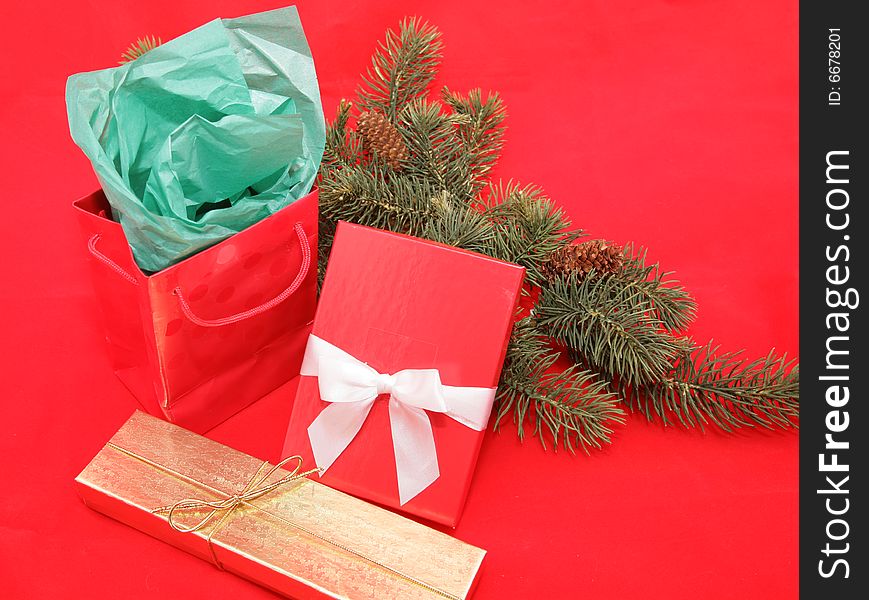 Christmas gifts with pine branches on a red background. Christmas gifts with pine branches on a red background.