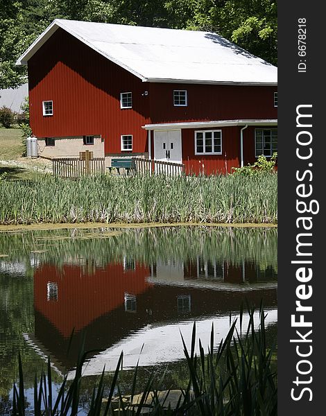 Red barn sitting on the side of the lake with a glassy reflection. Red barn sitting on the side of the lake with a glassy reflection.